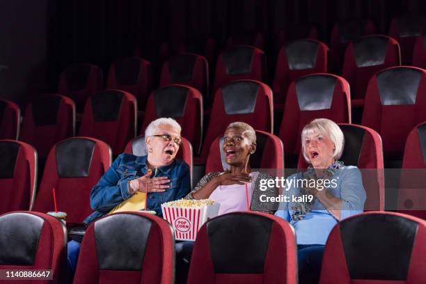 femmes âgées multi-ethniques dans le cinéma regardant le film - scary movie theatre photos et images de collection