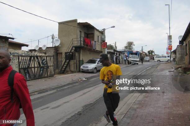 April 2019, South Africa, Johannesburg: A young man walks down a street in Johannesburg's Alexandra Township wearing an African National Congress...
