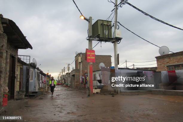 April 2019, South Africa, Johannesburg: A man walks through the mud in Johannesburg's Alexandra Township. South Africa holds its sixth democratic...