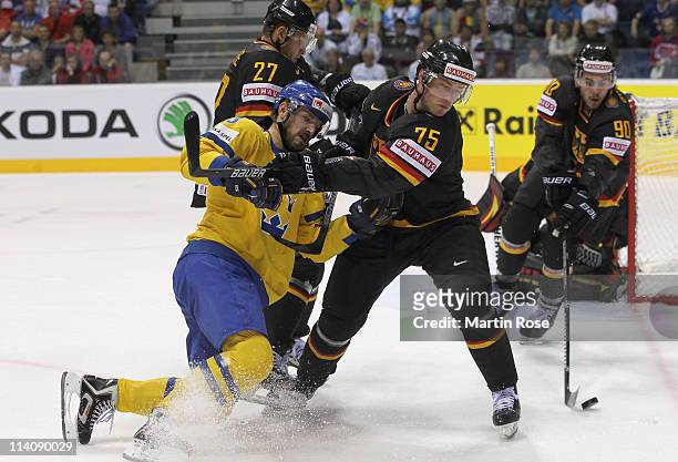 Niklas Persson of Sweden is checked by Marcus Kink of Germany during the IIHF World Championship quarter final match between Sweden and Germany at...