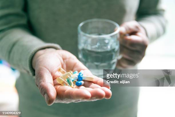 einnahme von arzneimitteln mit einem glas wasser - mann tabletten stock-fotos und bilder