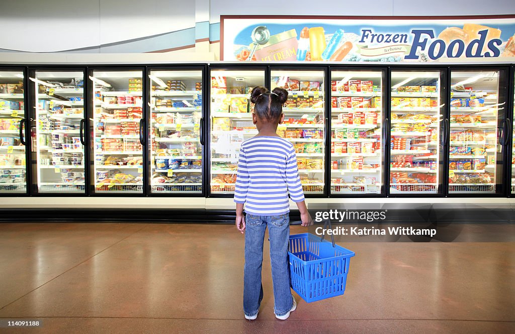 Girl standing in frozen food section.