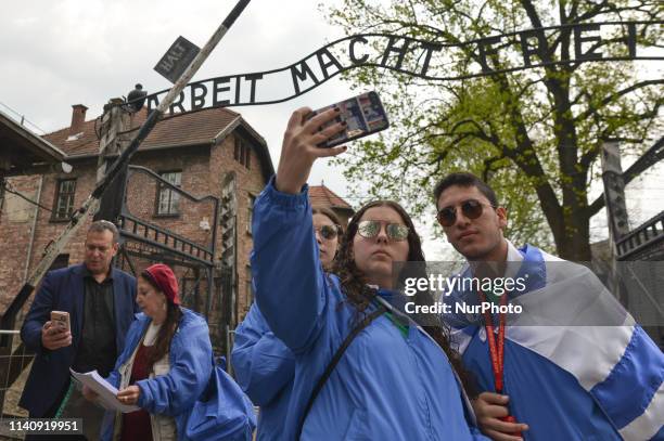 People take selfies outside 'Arbeit Macht Frei' sign near the main entrance gate to Auschwitz I. Under the theme 'Say No To Anti-Semitism' over...