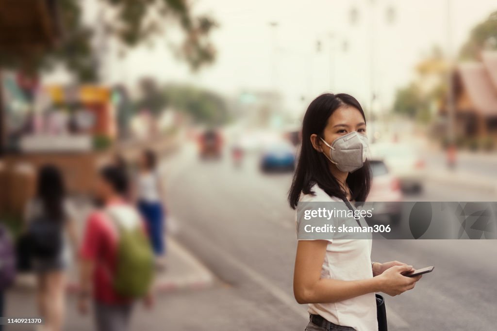 Asian girl on street and wearing pm 2.5 mask for safety from air pollution