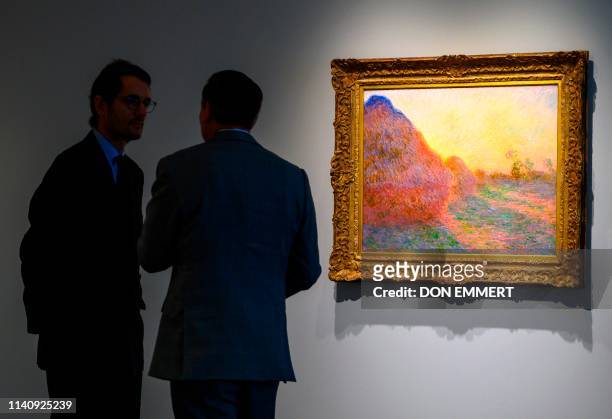 Sotheby's officials stand near one of Claude Monet's Meules during a media preview, for Sotheby's Impressionist & Modern Art and Contemporary Art...
