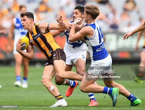 Jaeger O'Meara of the Hawks is tackled by Aaron Hall and Trent Dumont of the Kangaroos during the round three AFL match between the Hawthorn Hawks...