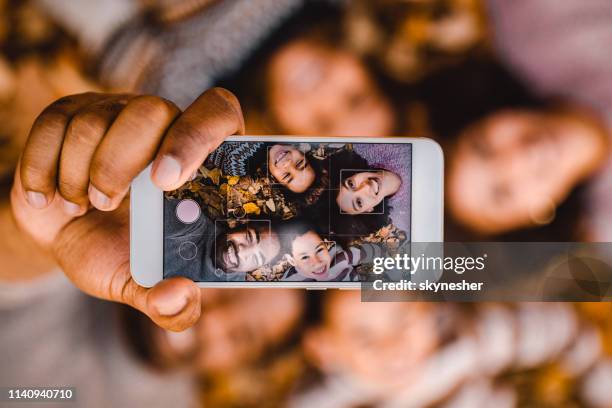 närbild av lycklig svart familj tar en selfie med mobil telefon i höst löv. - taking photo bildbanksfoton och bilder