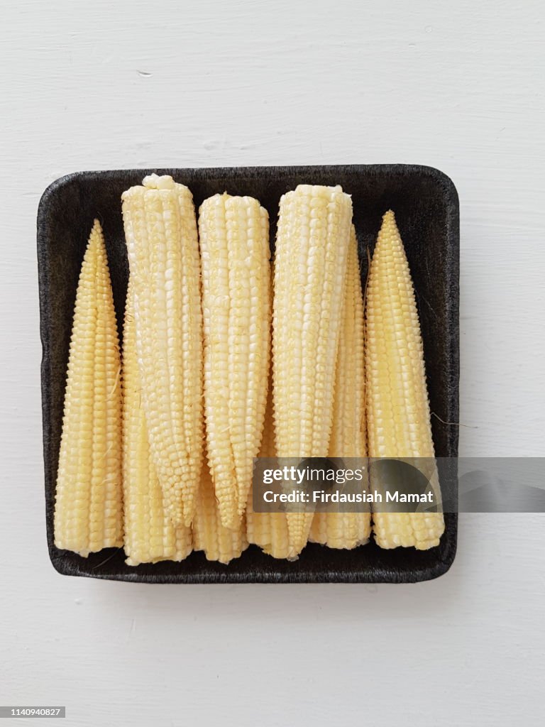 Fresh baby corn isolated against white background
