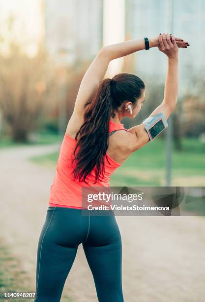 étirement de jeune femme avant l’entraînement - dorsal fin stock photos et images de collection