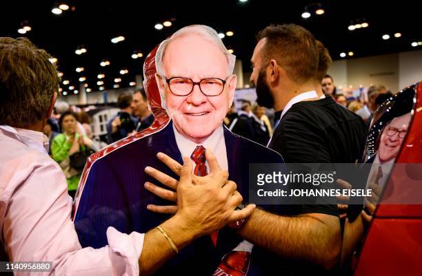 Shareholders pose with an stand-up illustration of Warren Buffett, CEO of Berkshire Hathaway, during the 2019 annual shareholders meeting in Omaha,...