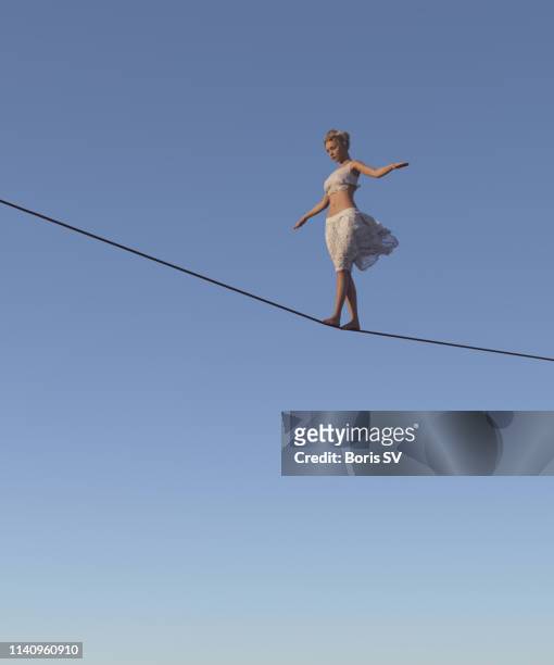 young woman walking on tightrope - hochseil stock-fotos und bilder