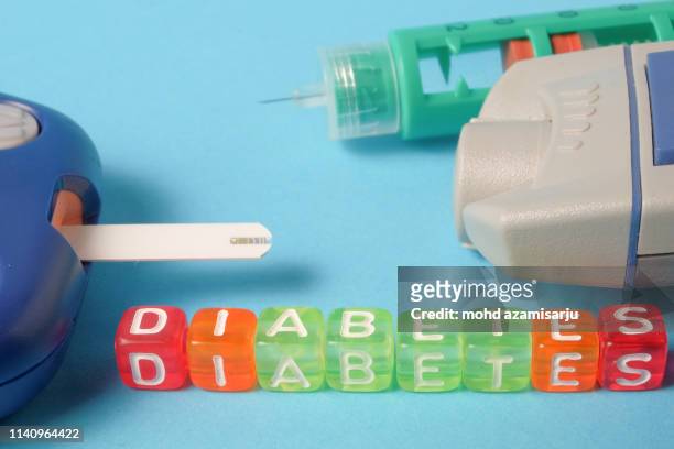 word diabetes next to insulin, lancing pen, blood glucose test strip and digital glaucometer - diabetes and nobody stock pictures, royalty-free photos & images