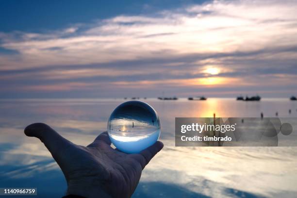 human hand holding a crystal ball by sevre niortaise river, deux-sevres, france - deux sevres stock pictures, royalty-free photos & images