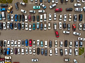 A view from above to the lines of parked cars. Heavy traffic in the parking lot. Searching for spaces in the busy car park. Cruising for parking in dormitory area. Difficulties of parking in the city