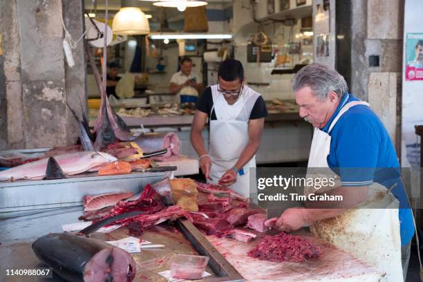 Sicily, Italy : Fishmongers cutting fillets of fish - tuna cutlets - on market stall at street market - Mercado - in Ortigia, Syracuse, Sicily"n