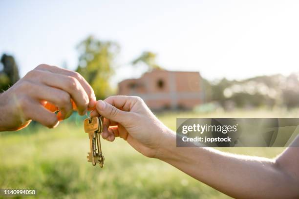 real estate agent giving house key the the new owner - agent and handing keys stockfoto's en -beelden