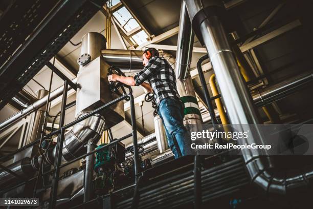 young technician is inspecting heating system in boiler room - gas turbine stock pictures, royalty-free photos & images