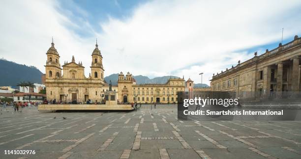 primatial cathedral of bogotá on bolivar square of bogota with capitolio nacional on the right hand side in bogota, colombia - bogota foto e immagini stock