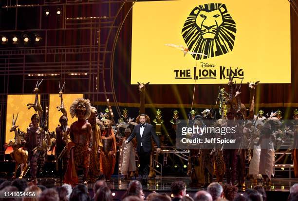 Host Jason Manford on stage with the cast of The Lion King during The Olivier Awards 2019 with Mastercard at the Royal Albert Hall on April 07, 2019...