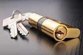 A new door lock on a dark background. A patent and keys to secure the front door. A black background.
