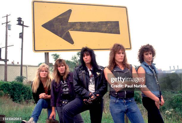 Portrait of American Rock group Shok Paris as they pose in front of a street sign, Cleveland, Ohio, September 15, 1987. Pictured are, from left, Kel...