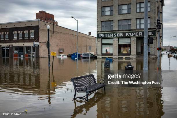Flood water surround a bench near the main breach in the Mississippi River in Davenport, Iowa on Friday, May 3, 2018.