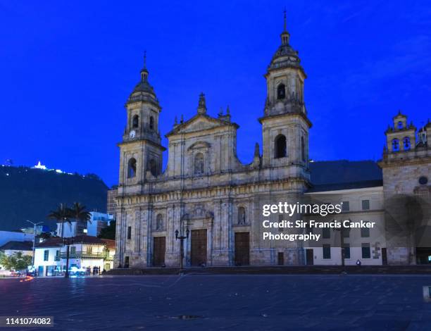 cathedral of bogotá illuminated at dusk on bolivar square (plaza bolivar) in bogota, colombia - la candelaria bogota stock-fotos und bilder