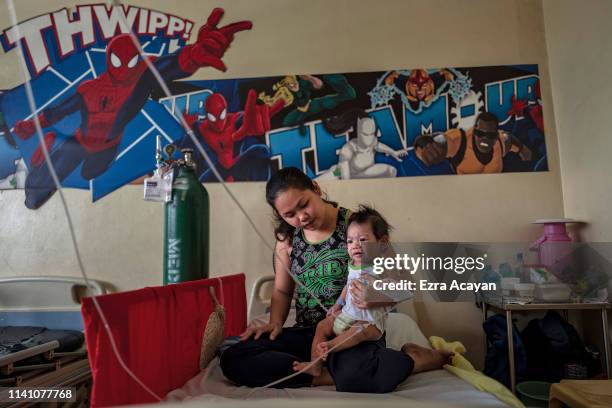 Iris Ladrillo tends to her four-month-old son Mark Robin, who is suffering from measles and being treated at a government-run hospital on May 4, 2019...