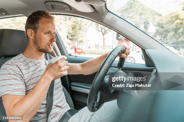 man drinking soda while driving - drinking soda in car stock pictures, royalty-free photos & images