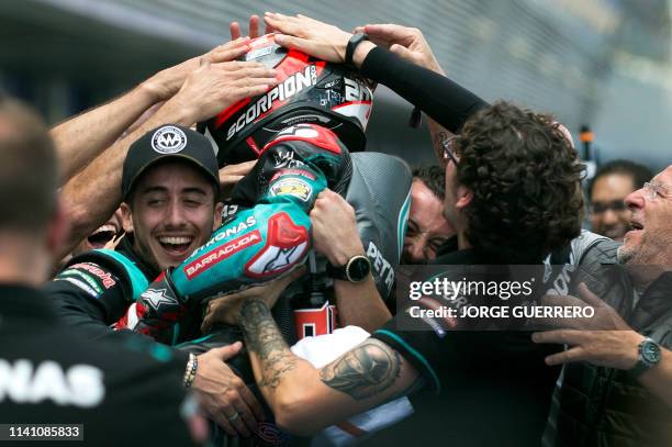 Petronas Yamaha SRT's French rider Fabio Quartararo is congratulated by teammates for earning the pole position for tomorrow's race during the MotoGP...