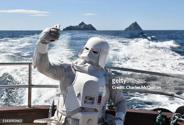 Member of the 501st Garrison dressed as a snowtrooper takes a selfie as he sails around Skellig Michael on May 4, 2019 in Portmagee, Ireland. The...