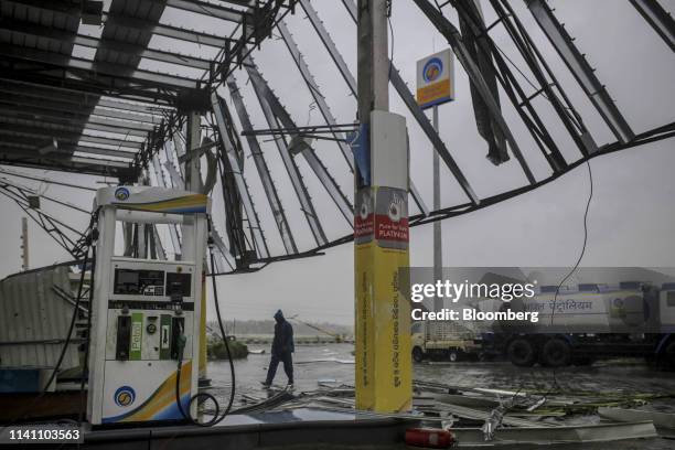 Man walks past a gas station after Cyclone Fani passes in the Puri district of Odisha, India, on Friday, May 3, 2019. A category 4 storm with strong...