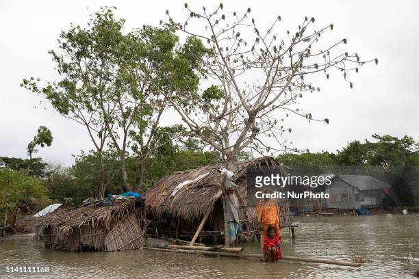 Salam Sheikh with his family menbers stands on a log in front of their home surrounded by high waters in Khulna on May 4 as Cyclone Fani reached...