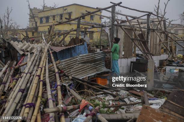 Woman stands near a damaged home after Cyclone Fani passed through Puri, Odisha, India, on Saturday, May 4, 2019. A category 4 storm with strong wind...