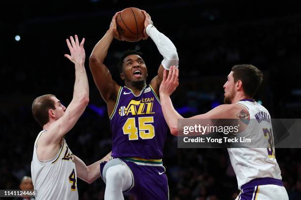 Donovan Mitchell of the Utah Jazz drives to the basket against Alex Caruso and Mike Muscala of the Los Angeles Lakers during the second half at...