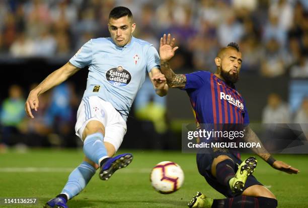 Celta Vigo's Uruguayan forward Maxi Gomez shoots to score a goal beside Barcelona's Chilean midfielder Arturo Vidal during the Spanish league...