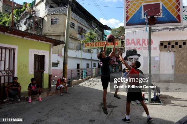 Two boys play basketball at Cotiza neighborhood on May 4, 2019 in Caracas, Venezuela. As the country goes through a political, economic and social...