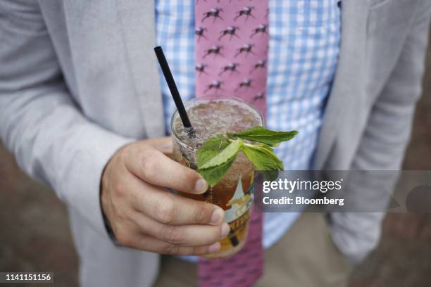 Racegoer holds a mint julep cocktail before the 145th running of the Kentucky Derby at Churchill Downs in Louisville, Kentucky, U.S., on Saturday,...