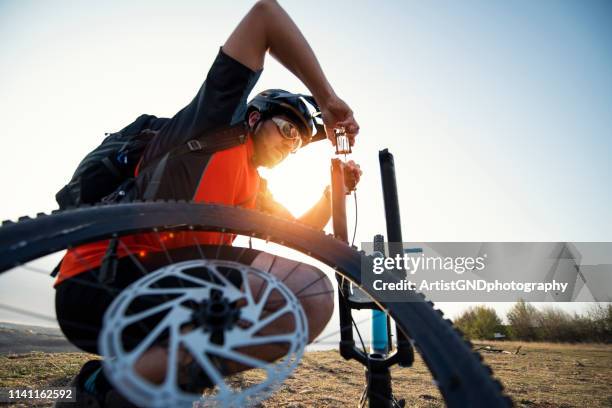 mountain biker reparera sin cykel gaffel och broms med verktyg. - luftpump bildbanksfoton och bilder