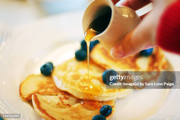 pouring maple syrup over pancakes - maple syrup pancakes stockfoto's en -beelden