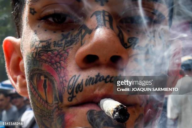 Man smokes a joint during a rally demanding the decriminalization of marijuana, in Medellin, Antioquia department, Colombia on May 4, 2019.