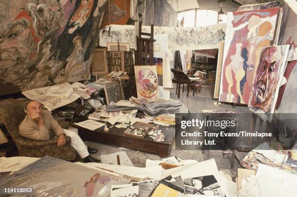 Polish-born British expressionist painter Feliks Topolski in his studio with some of his work, circa 1970.