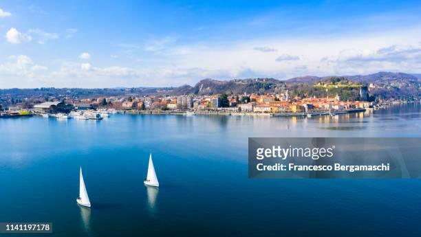 aerial view of a sailboat sailing in front of arona, lake maggiore, piedmont, italy. europe. - novara province stock pictures, royalty-free photos & images