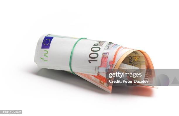 euro banknotes in a money roll - fajo de billetes de euro fotografías e imágenes de stock