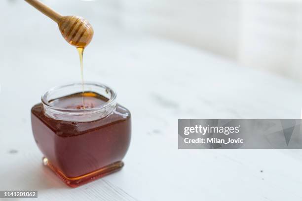 pouring honey into jar of honey - manuka honey stock pictures, royalty-free photos & images