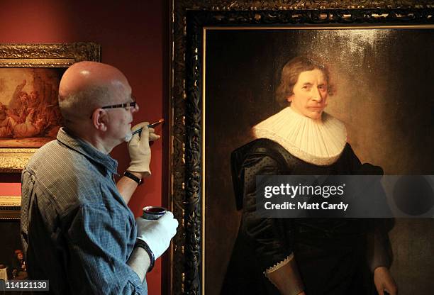 Roger Vercoe, a collection volunteer, touches up the frame paint at a preview of the new Holburne Museum ahead of its reopening on May 12, 2011 in...