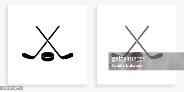 hockey stick and puck black and white square icon - hockey stick and puck stock illustrations