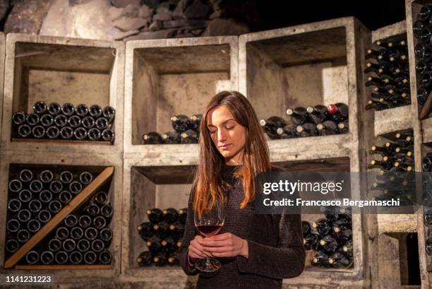 young girl looks a wine glass in the cellar. mese, valchiavenna, valtellina, lombardy, italy, europe. - wine making stock pictures, royalty-free photos & images