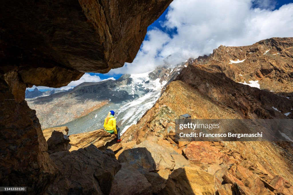 A girl looks the wild landscape. Corna Rossa Pass, Valmalenco, Valtellina, Lombardy, Italy, Europe.