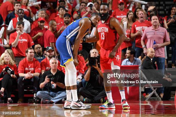 Kevin Durant of the Golden State Warriors and James Harden of the Houston Rockets look on during Game Three of the Western Conference Semifinals of...